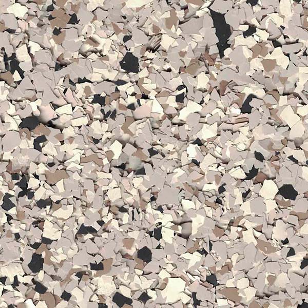 The image shows a texture that resembles a collage of scattered, irregular-shaped flakes in varied shades of beige, brown, and black against a neutral background.