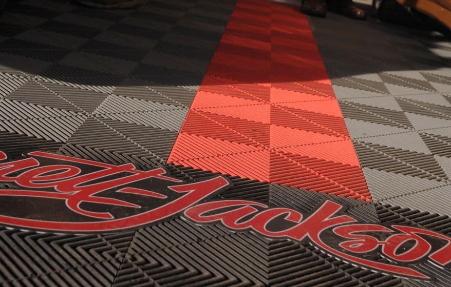 The image shows a patterned floor with a red and white checkerboard design interrupted by a bold red stripe and the "Rat Fink" logo.
